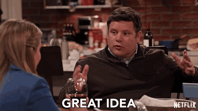 a man is sitting at a table with a glass of wine and a netflix logo in the background