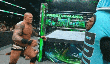 a wrestling match is taking place in front of a sign that says ' wrestlemania '