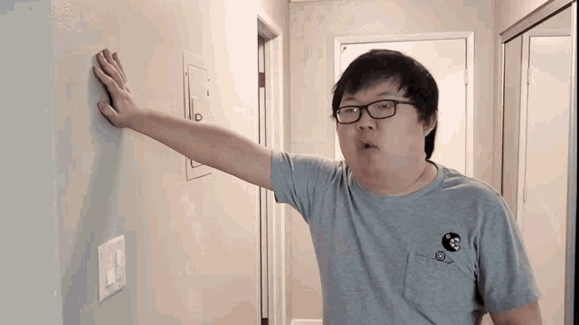 a man wearing glasses and a gray shirt with a panda on it