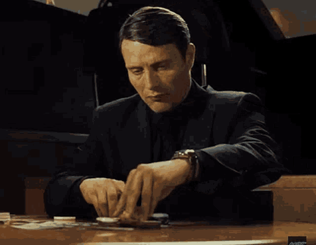 a man sitting at a table with a watch on his wrist