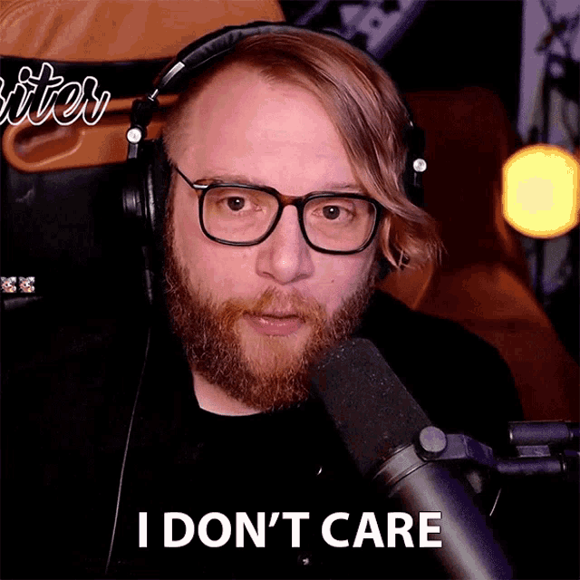 a man with glasses and headphones says i don 't care in front of a microphone