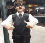 a young man wearing a suit and tie is giving a thumbs up .