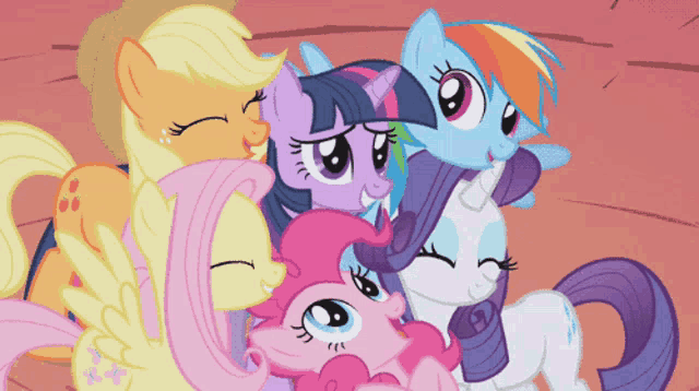 a group of ponies are hugging each other and looking at the camera