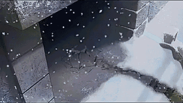 a fireplace with snow falling on it and a brick wall with snow falling on it .