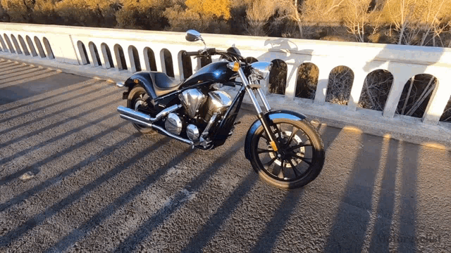 a black motorcycle is parked on the side of the road
