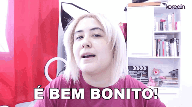 a woman says e bem bonito while wearing a purple shirt