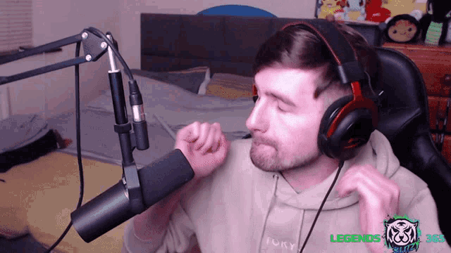 a man wearing headphones and a hoodie that says tory