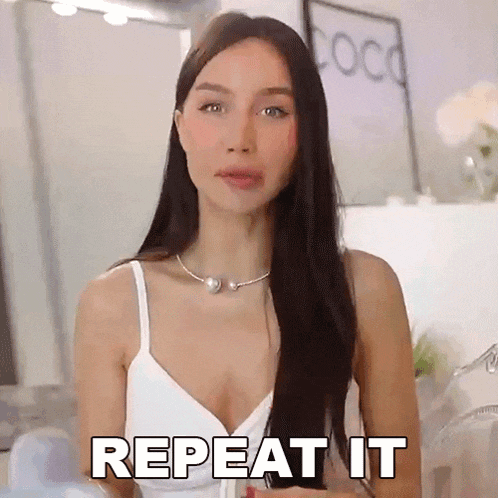 a woman is wearing a white tank top and a pearl necklace .