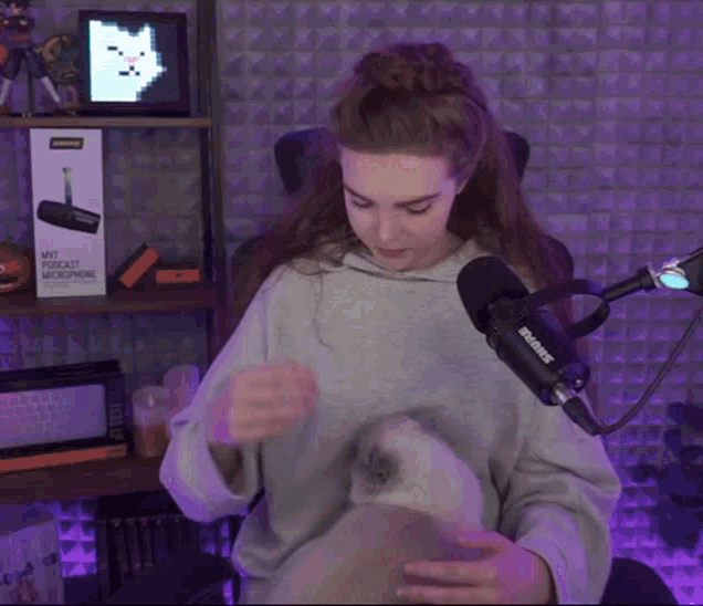 a woman sitting in front of a shure microphone