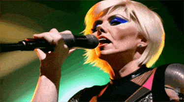 a woman singing into a microphone with the word gonmo on the bottom right