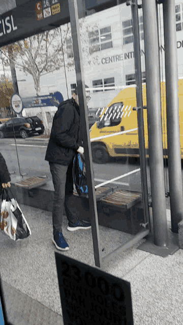 a man standing at a bus stop with a sign that says eisl on it