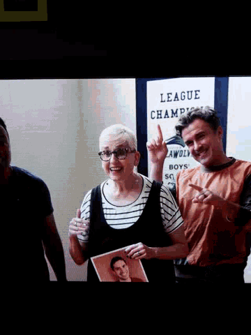 a man and a woman are posing for a picture in front of a sign that says league champions