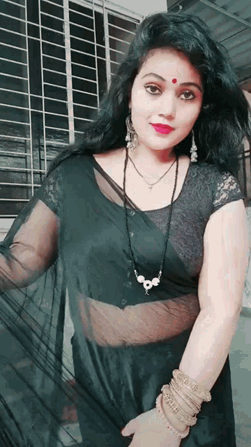 a woman wearing a black saree and a necklace with the word ' shree ' on it