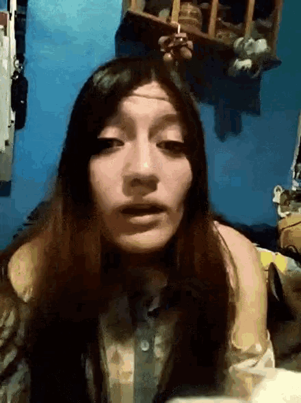 a woman with long hair is smoking a cigarette and making a funny face