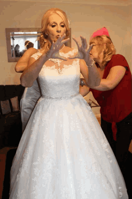 a woman in a red shirt helps a woman in a white dress