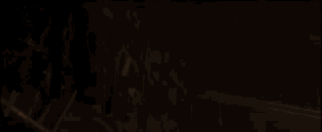 a man is kneeling down on the ground in a dark room