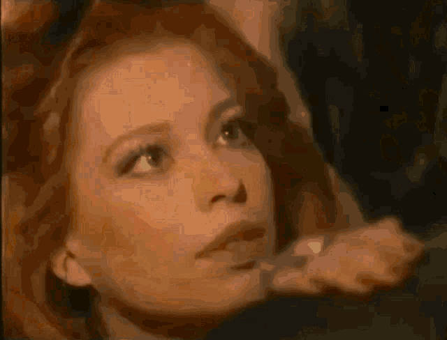 a woman with red hair is looking up at something