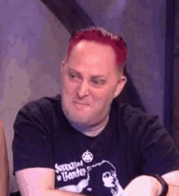 a man with red hair is wearing a black shirt .