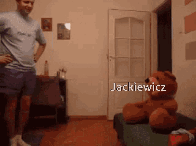 a man standing next to a teddy bear with the name jackiewicz written on it