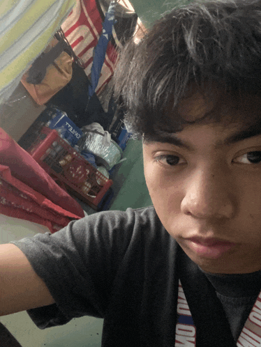 a young man taking a selfie with a camel branded lanyard around his neck