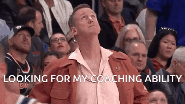 a man in a red jacket is looking up with the words looking for my coaching ability above him