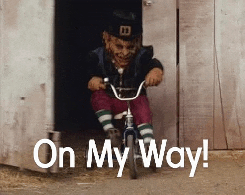 a leprechaun is riding a small bicycle in a doorway .