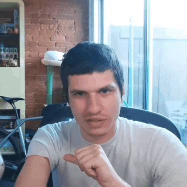 a man in a white shirt is pointing at the camera