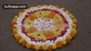 a circular pattern made of flowers and rice on the ground