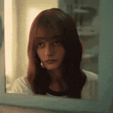 a woman looking at herself in a mirror