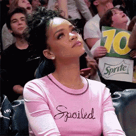 a woman wearing a pink shirt that says spoiled looks up