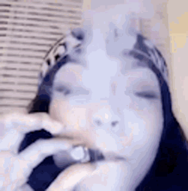 a woman is smoking a cigarette with smoke coming out of her mouth and nose .