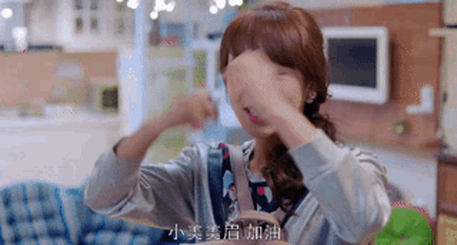 a woman covering her face with her hands with chinese writing on it
