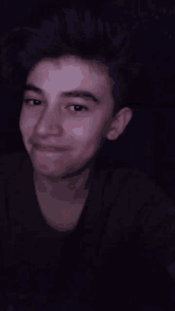 a close up of a young man 's face with a slight smile on his face .