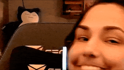 a woman is smiling in front of a stuffed animal .