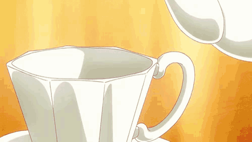 a cup of tea is being poured from a teapot into a cup and saucer .