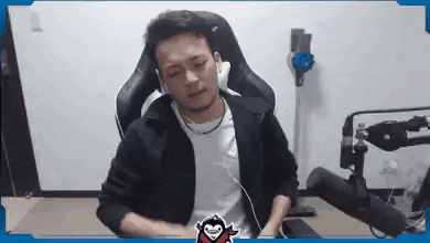 a man is sitting in a chair with headphones on and a microphone in front of him .