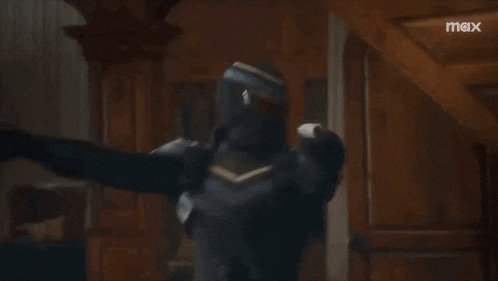 a man in a superhero costume is holding a gun in front of a wall that says max