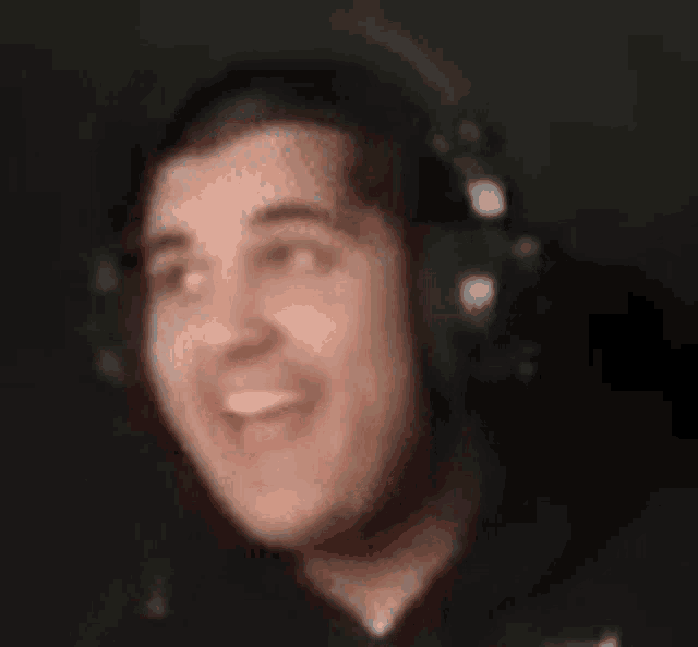 a man wearing headphones is smiling and making a funny face .