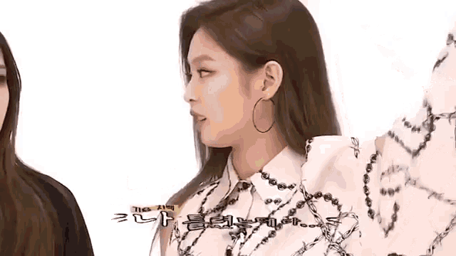 a close up of a woman wearing hoop earrings and a white shirt .