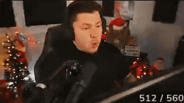 a man wearing headphones is sitting at a desk in front of a computer .