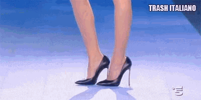 a woman is wearing a pair of black high heels on a white surface .