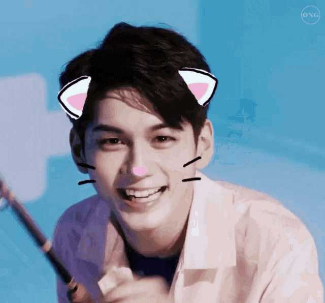 a young man with cat ears on his head is smiling .