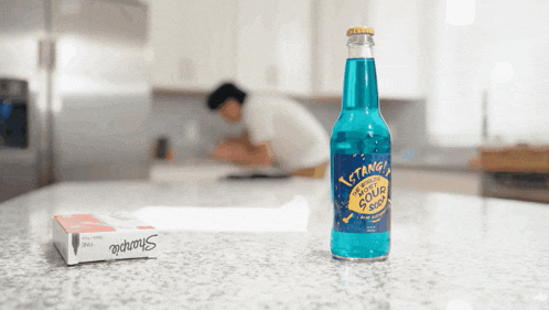 a bottle of cyanide flavored sour soda sits on a kitchen counter