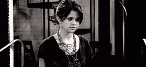 a black and white photo of a girl wearing a necklace .