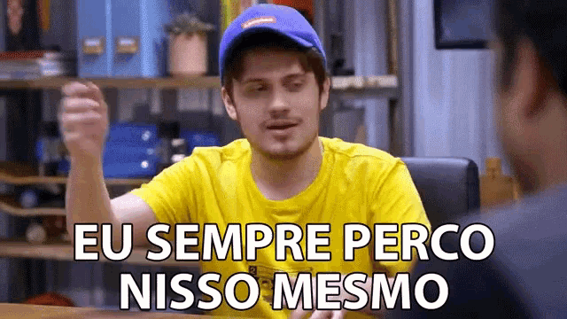 a man wearing a blue hat and a yellow shirt says eu sempre perco nisso mesmo