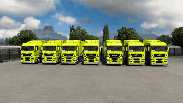 a row of man trucks are parked in a parking lot