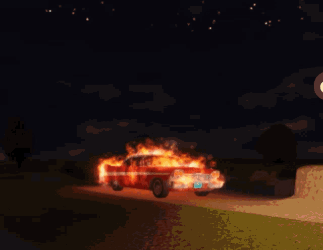 a red car is on fire at night