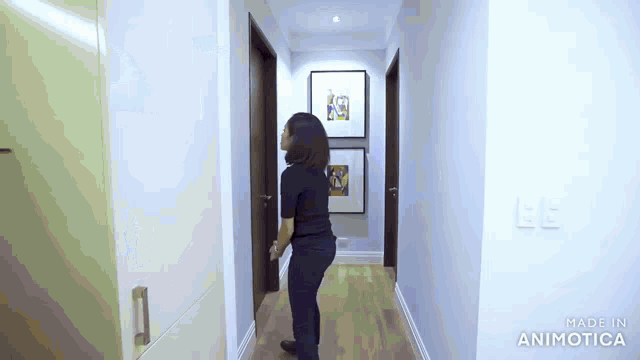 a woman is walking down a hallway with a made in animatica logo
