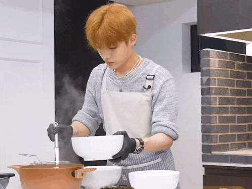 a man in an apron stirs a bowl of food