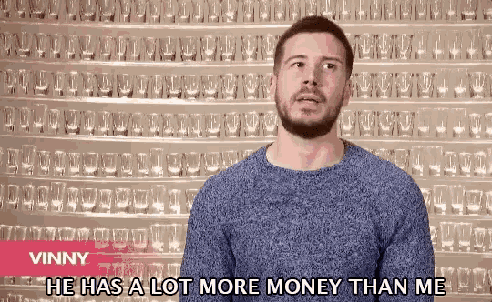 a man says vinny he has a lot more money than me in front of a wall of shot glasses